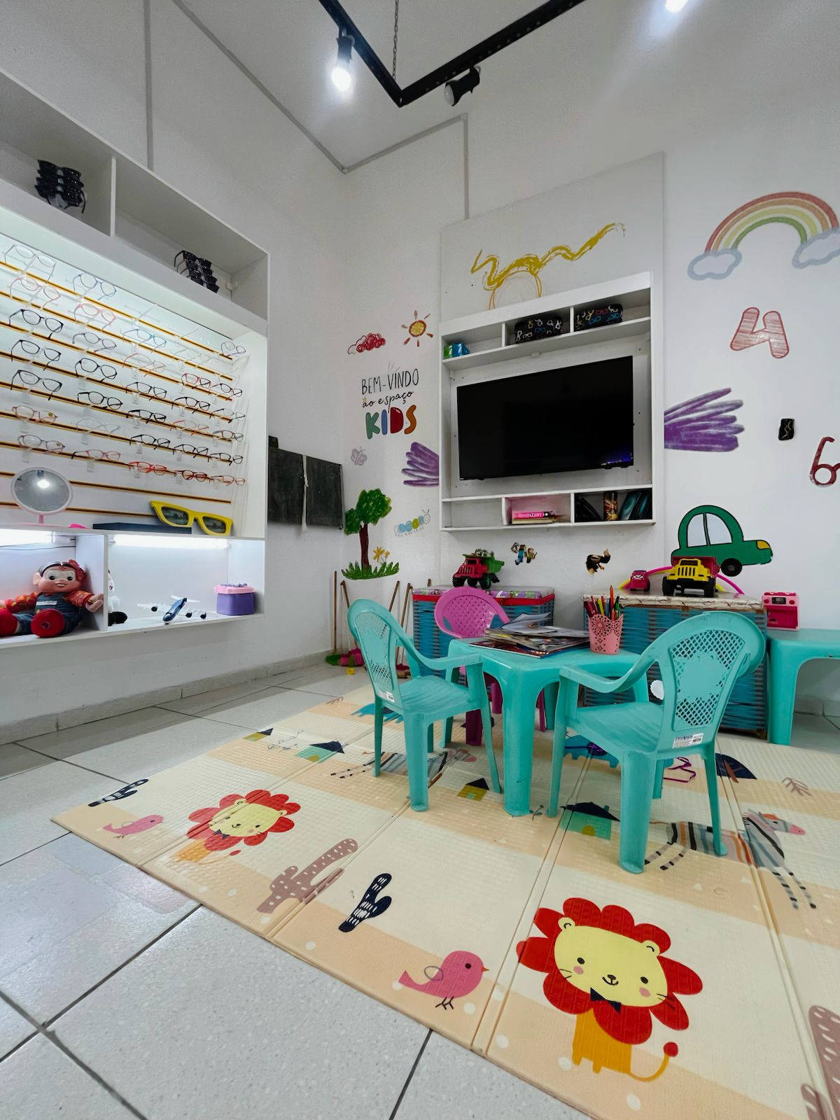Espaço kids da Sóótica, com mesinha, brinquedos e TV